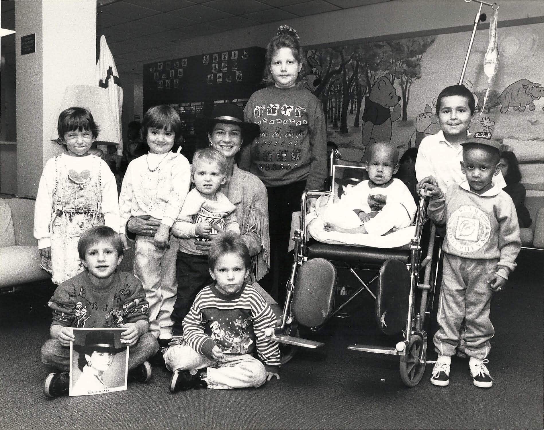 Children posing together, some holding pictures, in a playful setting.
